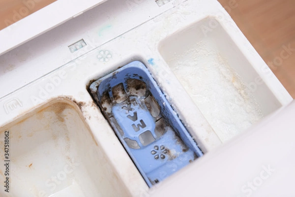 Fototapeta Dirty moldy washing machine detergent and fabric conditioner dispenser drawer compartment close up. Mold, rust and limescale in washing machine tray. Home appliances periodic maintenance concept