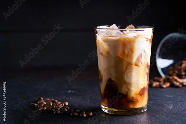 Obraz Tasty ice coffee with milk , cold drink in glass on dark background Copy space