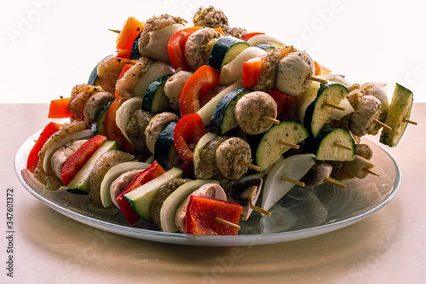 Fototapeta Delicious skewers with peppers, onions, chicken, zucchini and mushrooms.