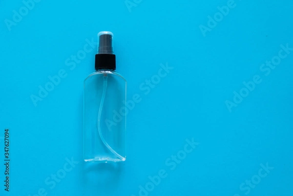Fototapeta Bottle of antiseptic, a bottle of hand sanitizer, hand sanitizer spray on a blue background, for the prevention of coronavirus. Bottle of antiseptic spray mockup, copy space for design.