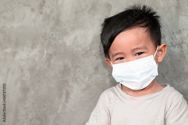 Obraz A boy wearing medical face mask for pollution or coronavirus,child itchy eyes and nose, Kid scratching nose while wearing protection mask.Protection against contagious disease, coronavirus.