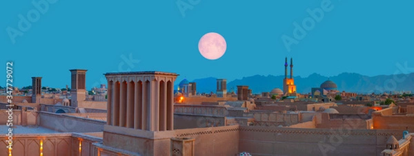 Obraz Historyczne miasto Jazd ze słynnymi wieżami wiatrowymi w tle i pełnią księżyca o zmierzchu - Jazd, IRAN „Elementy tego zdjęcia dostarczone przez NASA”