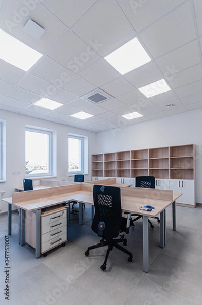 Fototapeta Interior of small new empty office space with desks and chairs