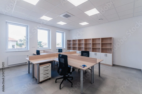 Fototapeta Interior of small new empty office space with desks and chairs