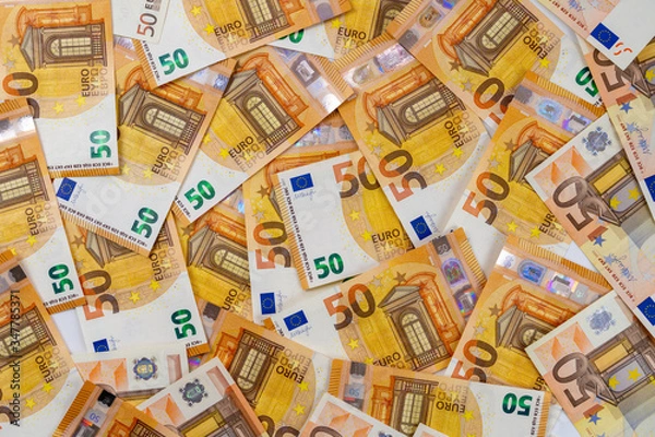Obraz Banknotes of 50 fifty euros are scattered in a chaotic manner. European currency blank for design, background. View from above.