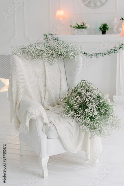 Obraz White armchair covered with white knited lap blanket