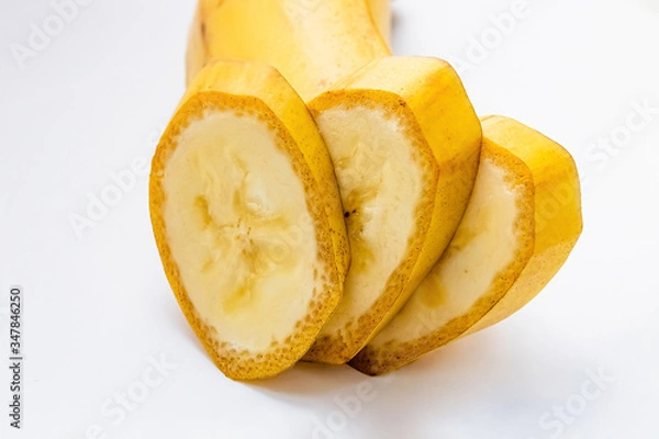 Fototapeta slices of a yellow banana in a cut on a white background macro shot