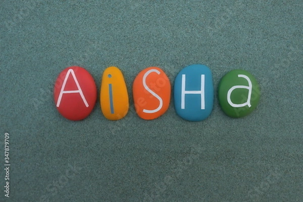 Obraz Aisha,  Arabic female given name composed with multi colored stone letters over green sand