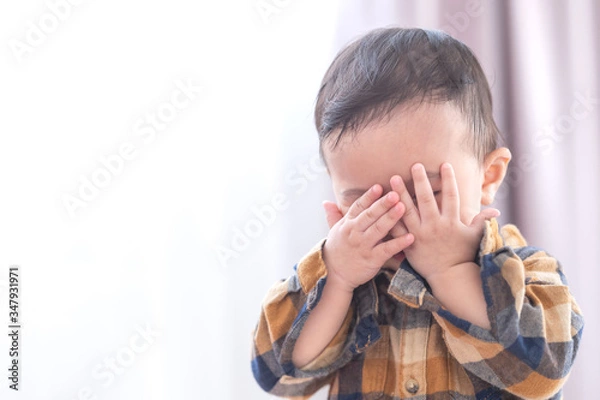Fototapeta Asian baby boy playing hide and seek hiding face with parents,Concepts of learning development of child by playing.