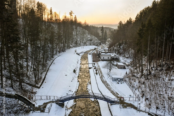 Fototapeta View from the dam in Miedzygorze, flowing river in a mountain valley in winter.