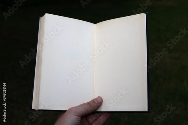 Obraz White open notebook held by hand. POV.