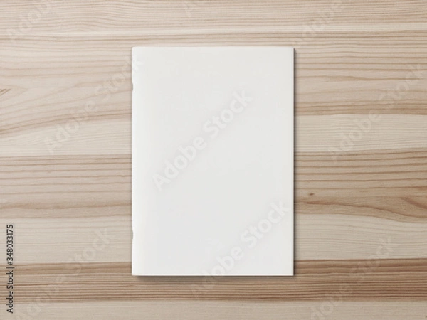 Fototapeta Blank Magazine or Brochure on brown wooden background. Front cover top view. Mockup concept for your showcase.