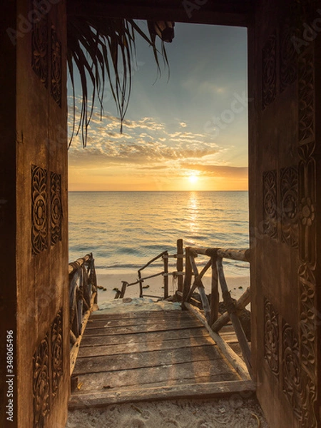 Fototapeta Beautiful dor way to white beach with sunrise in background. Zanzibar