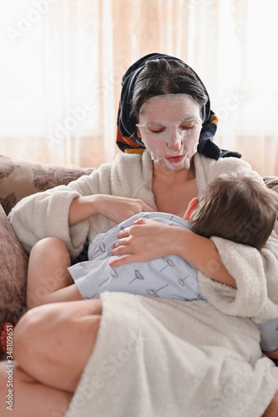 Fototapeta Portrait of a tired breast-feeding girl, with a moisturizing face mask.