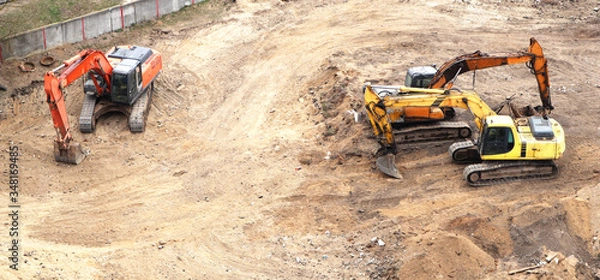 Fototapeta Excavator working to get rid of the rubbish in a demolition site. Demolition of the old industrial building.