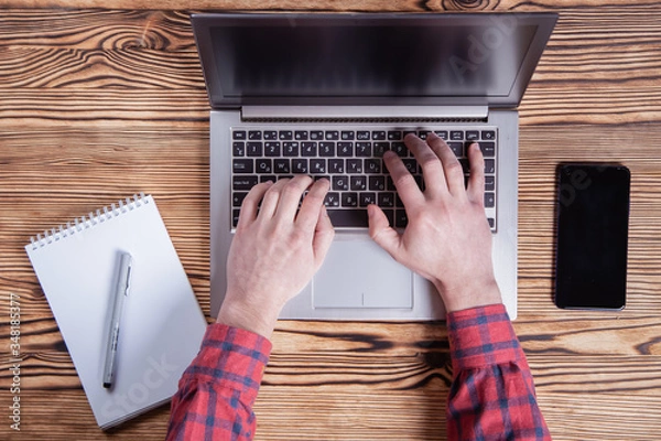 Obraz Workplace, male hands are typing on a laptop.