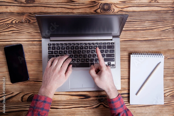 Obraz Workplace, male hands are typing on a laptop.