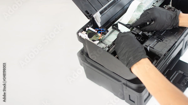 Fototapeta Printer repairman inspecting printer interior.Copy space. Concept of professional printer maintenance Technical assistance in office hardware Continuous repair of the ink system. Printer problems ..