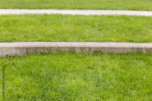 Obraz textures and lines, grass, concrete curb and path