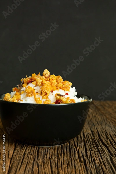 Fototapeta Chili paste fried pork skin and rice in black cup on wood table have dark background