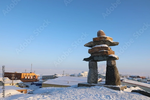 Obraz Single Inuksuk or Inukshuk landmark covered in snow on the top of the hill in the community of Rankin Inlet, Nunavut, Canada