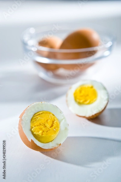 Fototapeta Cut in half and whole boiled eggs on the white background
