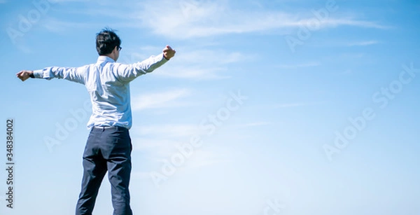 Obraz 青空の下でビジネスマンがリラックスしている