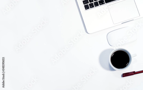 Fototapeta Laptop and coffee cup, top view of desk with white background, copy space