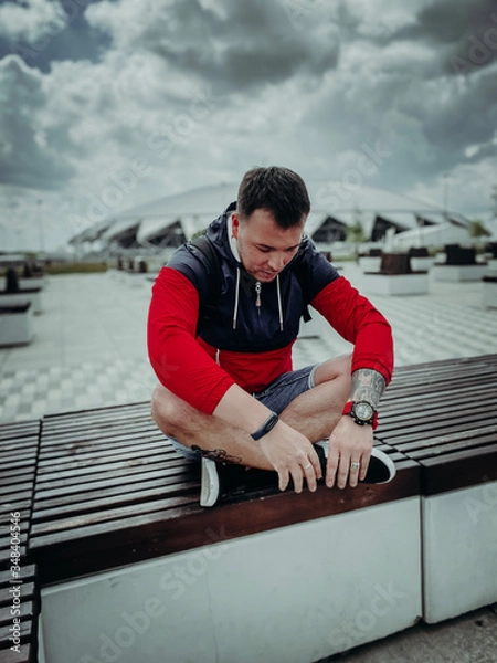 Obraz young man sitting on a bench