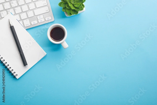 Fototapeta Blue desk office with laptop, smartphone and other work supplies with cup of coffee. Top view with copy space for input the text. Designer workspace on desk table essential elements on flat lay