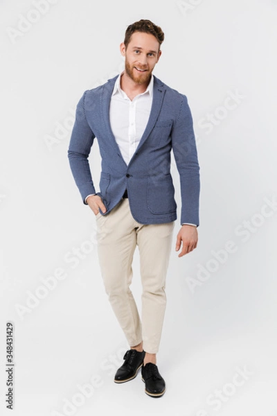 Fototapeta Image of joyful young man smiling and looking at camera