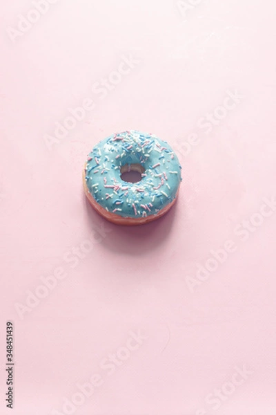 Fototapeta close-up view of donut with bubblegum flavor with frosted and filled with fruit jam and cream, colored glazed and sprinkled donuts on pink background