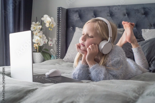 Fototapeta Pre teen girl playing on tablet. Virtual class lesson on video during self isolation at home. Distant remote video education. Modern school study for kids.