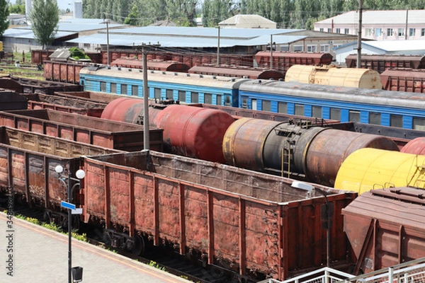 Fototapeta Old and rusty railway cars and trains are standing at the station. Commodity and passenger cars.