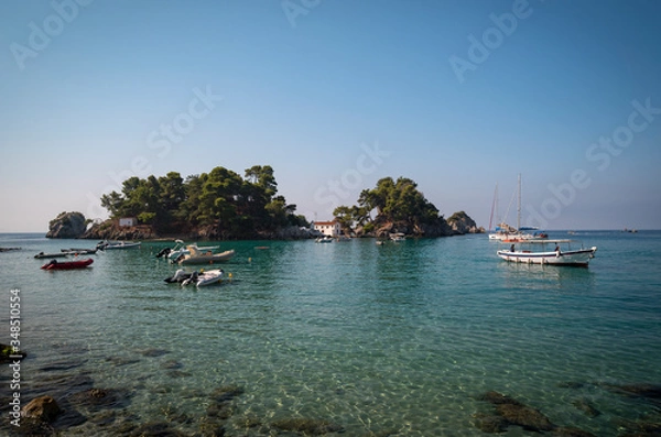 Fototapeta in the bay of Parga, an island and a chapel, boats are waiting on the blue Mediterranean sea,