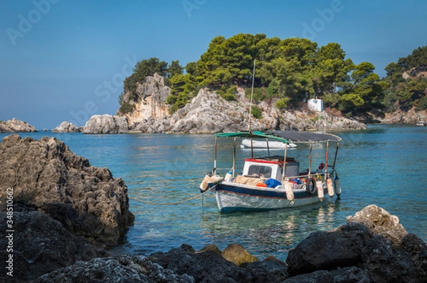 Fototapeta in the bay of Parga, an island and a chapel, boats are waiting on the blue Mediterranean sea,