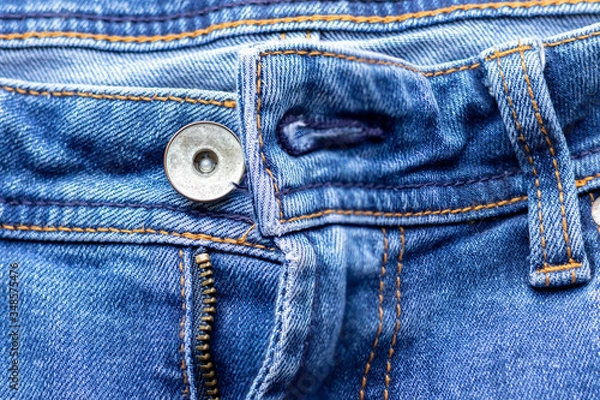 Fototapeta Jeans front with zipper open, button and pockets. Bright blue denim fabric texture background. Closeup view. Selective focus