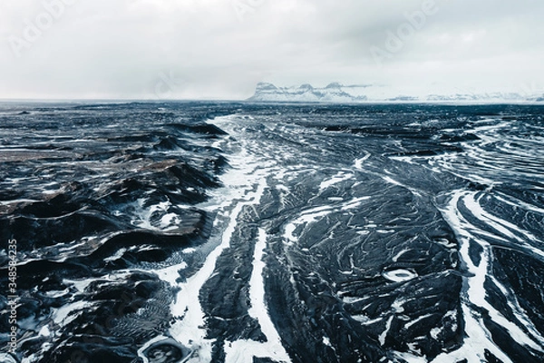 Fototapeta Aerial view of the volcanic desert on Iceland, in the background a glacier, black rock, filming location Interstellar