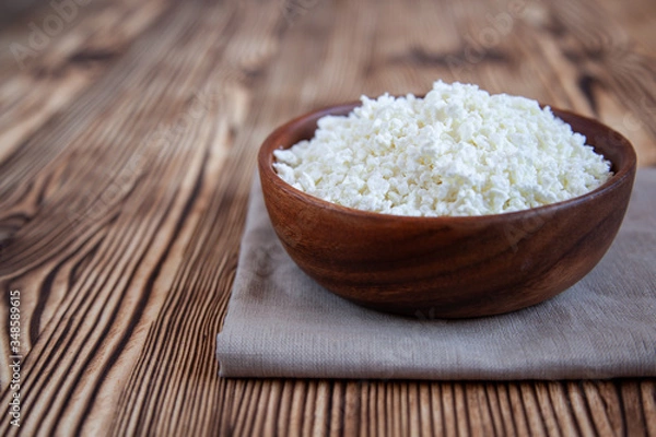 Obraz Wooden bowl with cottage cheese on the wooden table.