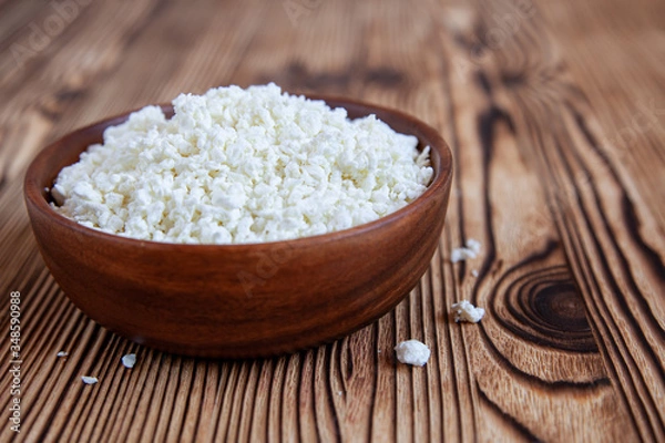 Obraz Wooden bowl with cottage cheese on the wooden table.