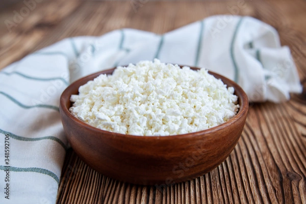 Obraz Wooden bowl with cottage cheese on the wooden table.