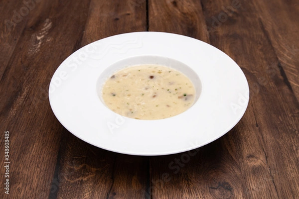 Fototapeta Cream soup with mushrooms and on wooden table. A plate of  Mushroom Cream-soup. 