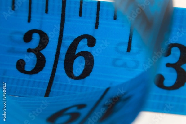 Fototapeta closeup or macro photo of the blue tape measure on the white background. focus on the 36 numbers. it could be used as diet, measuring, repair, tailor etc concepts.