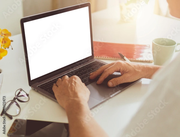 Fototapeta Close up of adult man hands typing on laptop - Man using notebook at home with blank mock up white empty screen - computer mockup copyspace display for shopping online, job search