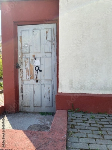 Obraz red door in a brick wall