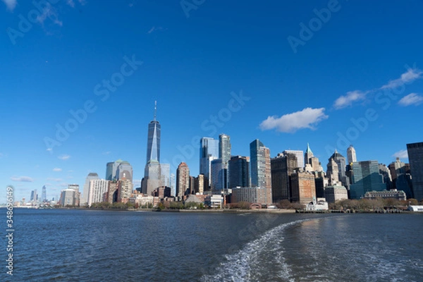 Fototapeta view of Manhattan New York from the hudson river and boat heading to statue of liberty