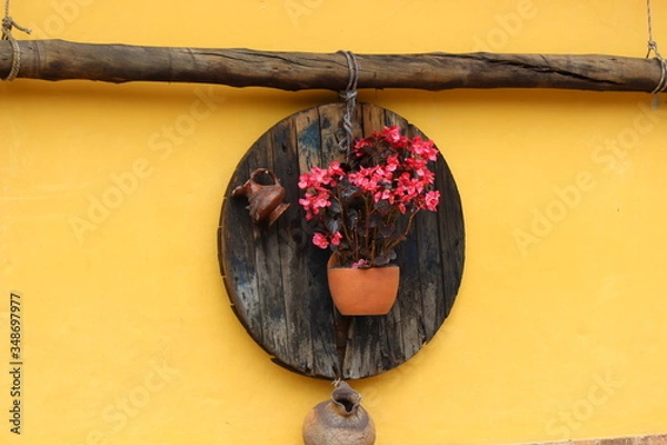 Fototapeta Vase hanging on the yellow and rustic wall