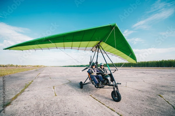 Obraz Moto hang-glider takes off on a ground airfield.