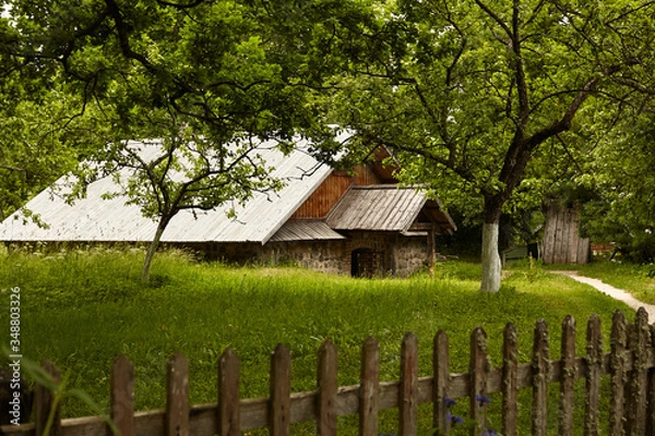 Obraz Old house in a garden. Historical agricultural estate. Old farm in the middle of a summer 