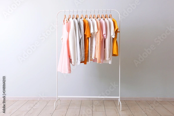 Fototapeta fashion clothes on a rack in a light background indoors. place for text